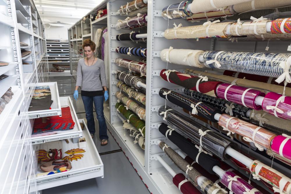 15岁的助理馆长克里斯塔·巴里在洛根人类学博物馆的纺织品储藏区...